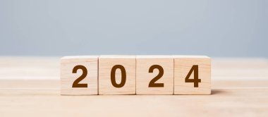 Masa arkasında 2024 yazı olan tahta küp bloğu. Çözüm, plan, gözden geçirme, hedef, başlangıç ve yeni yıl tatili kavramları