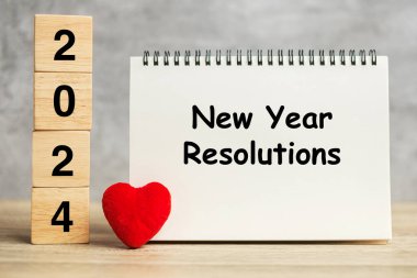 Yeni Yıl Çözüm Sözcükleri ve masada kırmızı kalp şekilli 2024 küp. Hedef, plan, sağlık, aşk ve Sevgililer Günü konsepti