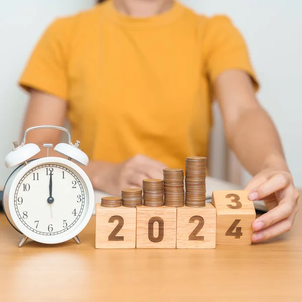 Happy New Year with vintage alarm clock and flipping 2023 change to 2024 block. Resolution, Goals, Plan, Action, Money Saving, Retirement fund, Pension, Investment and Financial concept