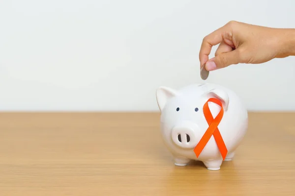 Leukemia, Kidney cancer day, world Multiple Sclerosis, CRPS, Self Injury Awareness month, Orange Ribbon with Piggy Bank for support illness life. Health, Donation, Charity, Campaign, Money Saving