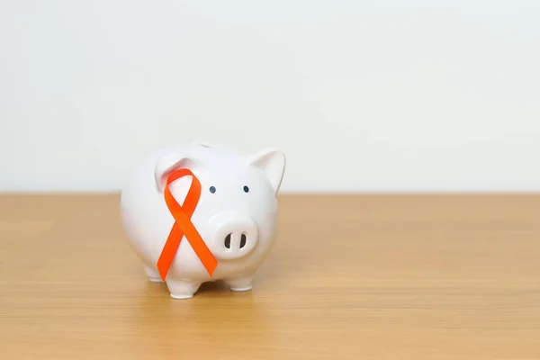 Leukemia, Kidney cancer day, world Multiple Sclerosis, CRPS, Self Injury Awareness month, Orange Ribbon with Piggy Bank for support illness life. Health, Donation, Charity, Campaign, Money Saving