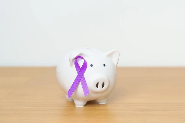 Purple Ribbon with Piggy Bank for Pancreatic, Esophageal, Testicular cancer, world Alzheimer, epilepsy, lupus, Sarcoidosis, Fibromyalgia and domestic violence Awareness month. World cancer day concept