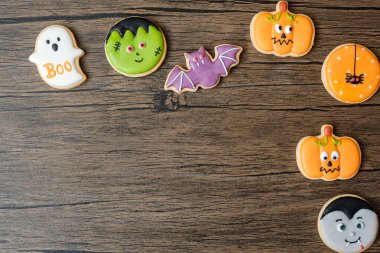 Ahşap masa arkasında komik kurabiyelerle Cadılar Bayramı 'nız kutlu olsun. Trick or Threat, Hello October, güz, şenlik, parti ve tatil konsepti