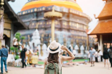 Beyaz şapkalı ve çantalı genç Asyalı gezgin Lampang Luang, Tayland, Lampang 'a turist ziyareti Asya Seyahati, Tatil ve yaz tatili konsepti