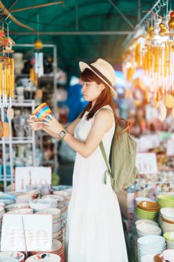 Genç Asyalı kadın gezgin elinde kupa turistler için seramik dükkanında, kız ziyaretinde Lampang, Tayland