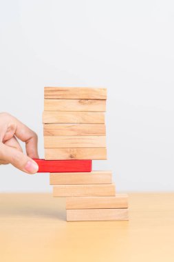 Kadın eli masadaki tahta domino taşlarını çekiyor. Kriz, Sonbahar İşletmeleri, Risk Yönetimi, Ekonomik durgunluk, Strateji ve Çözümler Konsepti