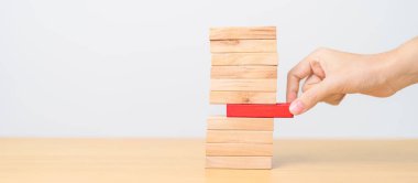 Kadın eli masadaki tahta domino taşlarını çekiyor. Kriz, Sonbahar İşletmeleri, Risk Yönetimi, Ekonomik durgunluk, Strateji ve Çözümler Konsepti