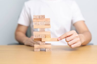 Elle çekilen tahta blok kulesi masanın üzerinde. İş planlaması, Risk Yönetimi, Çözüm, lider, strateji, kriz, düşen iş ve ekonomik durgunluk kavramı