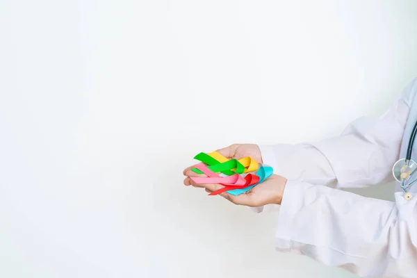 stock image World cancer day, February 4. Doctor hold colorful ribbons, blue, yellow, red, green, white, pink and grey for supporting people living and illness. Health, Medical, awareness and Insurance concept