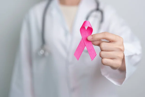 Pink October Breast Cancer Awareness month, doctor with pink Ribbon in hospital for support people life and illness. National cancer survivors month, Mother and World cancer day concept