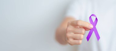 Şiddet, Pankreas, Özofagus, Testis kanseri, Alzheimer, epilepsi, lupus, Sarkoidoz ve Fibromiyalji için mor kurdele tutan kadın. Farkındalık ayı ve Dünya Kanser Günü konsepti