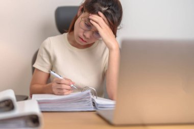 Dizüstü bilgisayar kullanan Asyalı kadın, ofiste baş ağrısı ve uykusuzluk çeken yorgun bayan iş kadını, gece geç saatlerde evde bilgisayarlı yorgun kadın. Çalışma Hayatı Dengesi kavramı