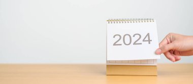 Masa arkasında 2024 Yıllık Takvim. Mutlu Yıllar, Çözüm, Hedefler, Plan, Eylem, Görev ve Mali Konsept