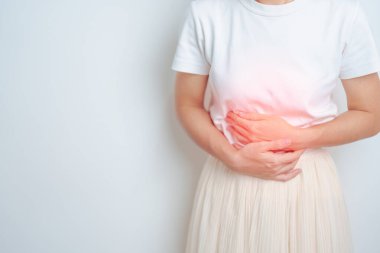 Karın ağrısı çeken bir kadın. Mide, yumurtalık ve rahim ağzı kanseri, rahim ağzı rahatsızlığı, endometriyozis, histerektomi, rahim fibroidi, üreme, adet görme, ishal, sindirim sistemi ve hamilelik.