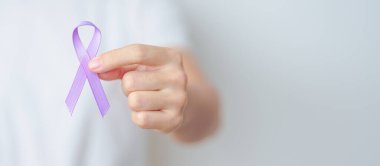 Karın, Şiddet, Pankreas, Esophageal, Testis kanseri, Alzheimer, epilepsi, lupus, Sarkoidoz ve Fibromiyalji için mor kurdele tutan kadın. Farkındalık ayı ve Dünya Kanser Günü konsepti