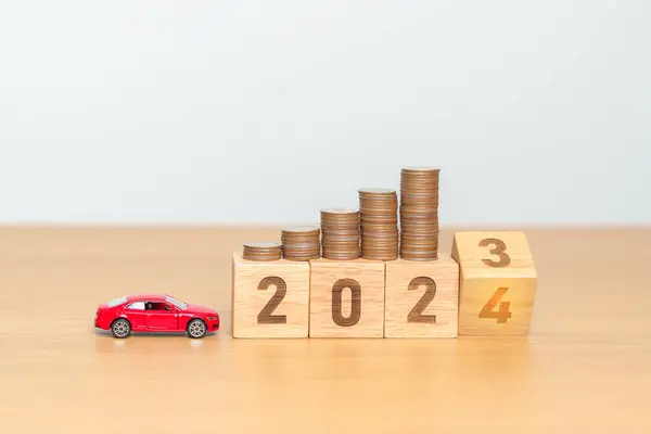 2023 flipping to 2024 year block with car model and Coins Money stack for deposit and Automobile Tax. Money Saving, Car Insurance, Financial, vehicle Repair and Maintenance and New Year concept