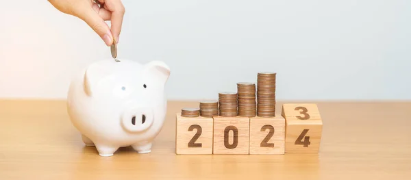 Happy New Year with piggy bank and flipping 2023 change to 2024 block. Resolution, Goals, Plan, Action, Money Saving, Retirement fund, Pension, Investment and Financial concept
