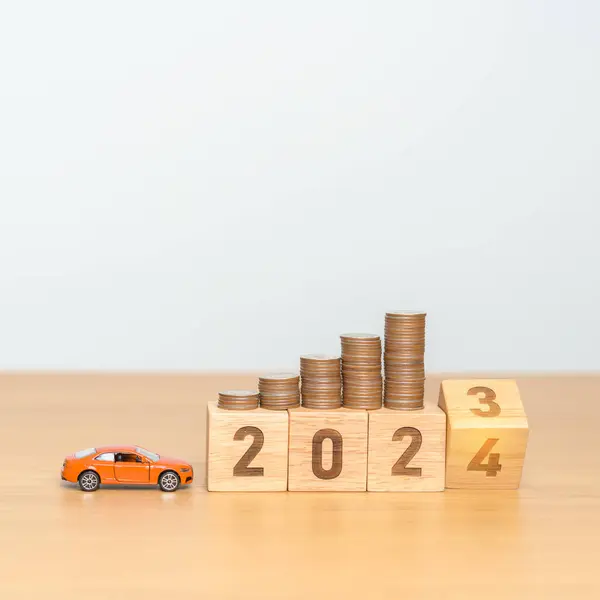 2023 flipping to 2024 year block with car model and Coins Money stack for deposit and Automobile Tax. Money Saving, Car Insurance, Financial, vehicle Repair and Maintenance and New Year concept
