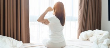 Evde yatakta yatarken kolu ağrıyan bir kadın, uyandıktan sonra kas hasarı ve ağrısı. Sağlık ve Tıp Konsepti