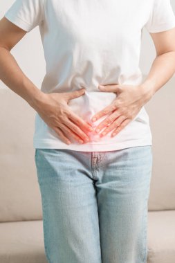Kadın problemi ve endometriyozis, histerektomi ve regl evdeki kanepede, karın ağrısı, kabızlık ve ishal nedeniyle karın ağrısı olan bir kadın.