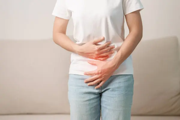 woman having abdomen ache due to Stomach pain, digestion with constipation or Diarrhea from food poisoning, female problem and Endometriosis, Hysterectomy and Menstrual on the sofa at home