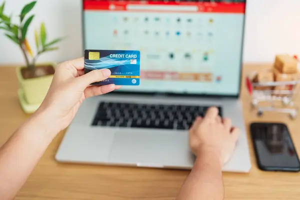 woman hand holding credit card and using laptop with mobile phone for online shopping while making order. Marketplace platform website, technology, ecommerce, shipping delivery and online payment