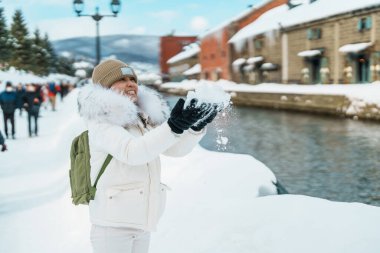 Otaru 'yu ziyaret eden kadın turist, süveter giyen mutlu gezgin kış mevsiminde Otaru kanalını geziyor. Japonya 'nın Hokkaido şehrinde önemli ve popüler bir yer. Seyahat ve Tatil kavramı