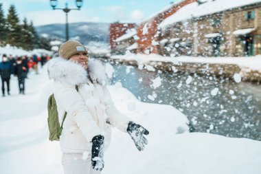 Otaru 'yu ziyaret eden kadın turist, süveter giyen mutlu gezgin kış mevsiminde Otaru kanalını geziyor. Japonya 'nın Hokkaido şehrinde önemli ve popüler bir yer. Seyahat ve Tatil kavramı