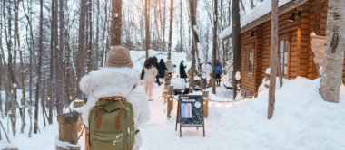 Furano 'yu ziyaret eden kadın turist, kazaklı gezgin kışın Snow' la Ningle Terrace Cottages 'ı gezen gezgin. Japonya 'nın Hokkaido şehrinde önemli ve popüler bir yer. Seyahat ve Tatil kavramı