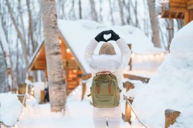 Furano 'yu ziyaret eden kadın turist, kazaklı gezgin kışın Snow' la Ningle Terrace Cottages 'ı gezen gezgin. Japonya 'nın Hokkaido şehrinde önemli ve popüler bir yer. Seyahat ve Tatil kavramı