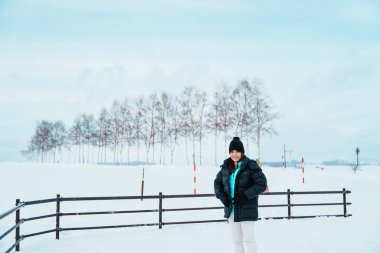 Biei 'yi ziyaret eden kadın turist, kışın Snow' la gezen kazaklı gezgin manzarası. Japonya 'nın Hokkaido şehrinde önemli ve popüler bir yer. Seyahat ve Tatil kavramı