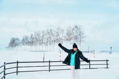 Biei 'yi ziyaret eden kadın turist, kışın Snow' la gezen kazaklı gezgin manzarası. Japonya 'nın Hokkaido şehrinde önemli ve popüler bir yer. Seyahat ve Tatil kavramı