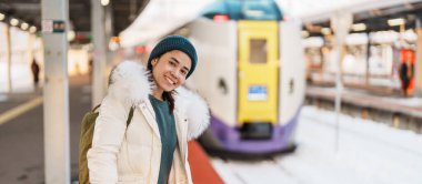 Kışın Snow 'la tren istasyonunda çanta taşıyan bir kadın turist. Hakodate, Hokkaido, Japonya. Seyahat ve Tatil konsepti.