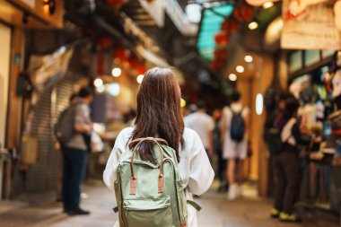 Tayvan 'da gezen kadın gezgin, şapka ve sırt çantasıyla gezen turist Jiufen Eski Cadde pazarında alışveriş yapan kadın. Taipei şehrinin yakınlarındaki önemli ve popüler yerler. Seyahat ve Tatil kavramı