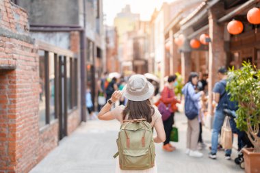 Tayvan 'a gezmeye gelen kadın gezgin, sırt çantası ve şapkasıyla gezmeye gelen turist Bopiliao Tarihi Bloğu' nda, Taipei şehrinin dönüm noktası ve popüler eğlenceleri. Asya Seyahati