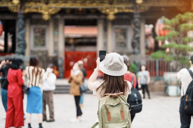 Tayvan 'da gezen bir kadın gezgin, Longshan Tapınağı' nda gezen şapkalı bir turist, Wanhua Bölgesi, Taipei Şehri 'ndeki Çin halk dinî tapınağı. Şehir simgesi ve popüler. Seyahat ve Tatil kavramı