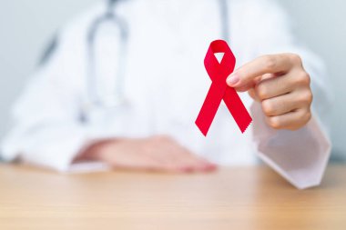 Aralık Dünya Yardım Günü için kırmızı kurdeleli doktor, bağışıklık yetmezliği sendromu, çoklu miyelom kanseri farkındalığı ayı ve Ulusal Kırmızı Kurdele haftası. Sağlık ve dünya kanser günü konsepti