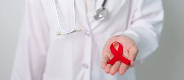 stock image Doctor with Red Ribbon for December World Aids Day, acquired immune deficiency syndrome, multiple myeloma Cancer Awareness month and National Red ribbon week. Healthcare and world cancer day concept