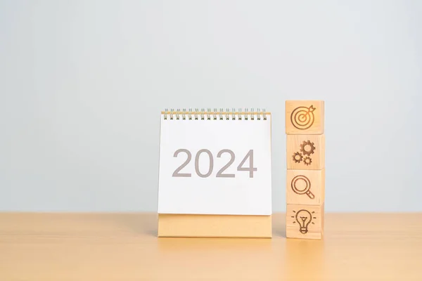 2024 Year Calendar with wood Business block, Goal, strategy, target, Resolution, mission, action, growth, teamwork, plan, idea and New Year start concept