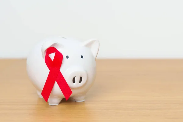 December World Aids Day, acquired immune deficiency syndrome, Red Ribbon with Piggy Bank for support illness life. Health, Donation, Charity, Campaign, Money Saving, Fund and world cancer day concept