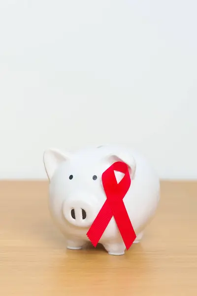 December World Aids Day, acquired immune deficiency syndrome, Red Ribbon with Piggy Bank for support illness life. Health, Donation, Charity, Campaign, Money Saving, Fund and world cancer day concept