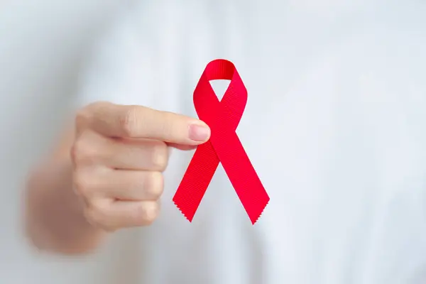 woman with Red Ribbon for December World Aids Day, acquired immune deficiency syndrome, multiple myeloma Cancer Awareness month and National Red ribbon week. Healthcare and world cancer day concept