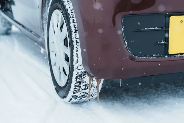 Car wheel tires on the road covered with snow in winter season, Vehicle on snowy way at snowfall