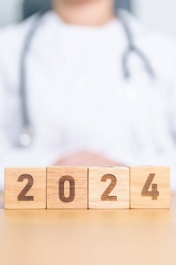 Doktor eli 2023 'ten 2024' e çeviriyor. Sağlık, Sağlık, Sigorta ve Sağlık Konseptleri İçin Mutlu Yıllar