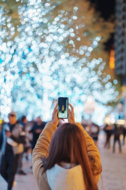 Gezgin Roppongi Hills Noel Aydınlatması 'nı ziyaret ediyor ve Tokyo Kulesi' nde fotoğraf çekiyor. Tokyo, Japonya 'da mutlu bir turist kadın Noel pazarında duruyor. Seyahat, tatil ve kutlama konsepti
