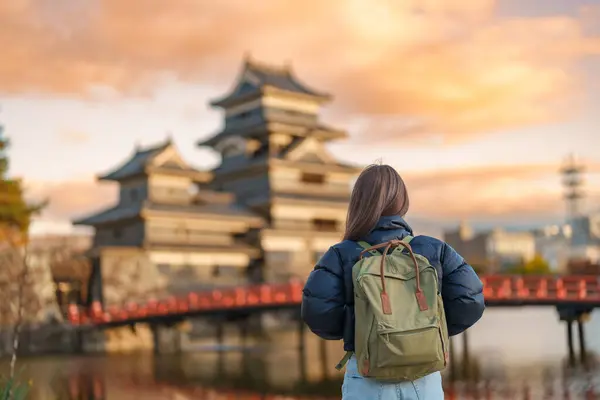 Woman tourist Visiting in Matsumoto, happy Traveler sightseeing Matsumoto Castle or Crow castle. Landmark and popular for tourists attraction in Matsumoto, Nagano, Japan. Travel and Vacation concept