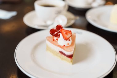 Taze çilekli ev yapımı peynirli kek ve sıcak çay fincanı. Sevgililer Günü kutlamaları için tatlı ve içecek.