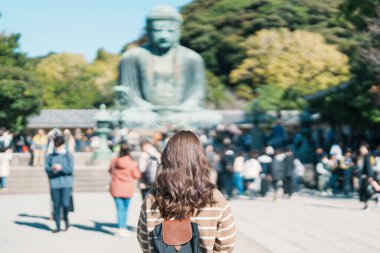 Kamakura, Kanagawa, Japonya 'da kadın turist ziyareti. Mutlu gezginler Büyük Buda heykelini geziyor. Tokyo yakınlarındaki turistler için önemli ve popüler bir yer. Seyahat ve Tatil kavramı