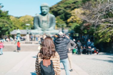 Kamakura, Kanagawa, Japonya 'da kadın turist ziyareti. Mutlu gezginler Büyük Buda heykelini geziyor. Tokyo yakınlarındaki turistler için önemli ve popüler bir yer. Seyahat ve Tatil kavramı