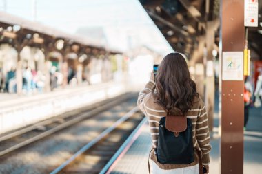 Kamakura, Kanagawa, Japonya 'da tren bekleyen ve ziyaret eden kadın turist. Gezginler Kamakura tren istasyonunu gezerken mutlu olsun. Tokyo yakınlarındaki turistler için önemli ve popüler bir yer. Seyahat ve Tatil